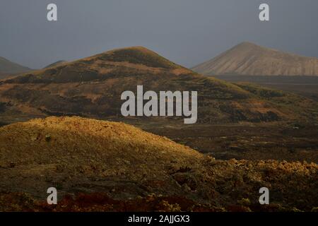 Schöne Vulkanlandschaft am frühen Morgen in Lanzarote, Kanarische Inseln, Spanien. Die calima Wind macht ein surreales Licht. Stockfoto
