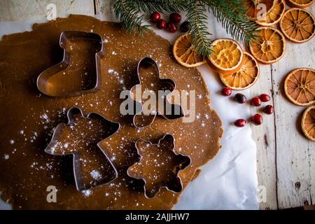 Über dem Schuss der weihnachtsfeiertage Keksschneider auf Teig drinnen Stockfoto