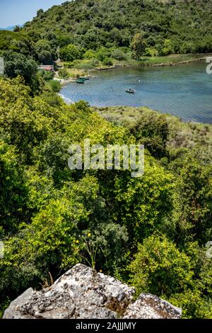 Hohen Winkel sonniger Frühlingstag Blick auf Lagune Salz See, das Tal und die Berge im Nationalpark von Butrint in Albanien, Europa. Mann in einem Boot Stockfoto
