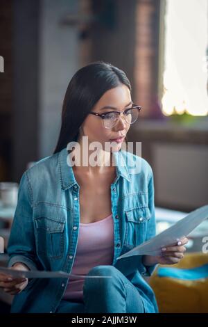 Ernsthafte intelligente junge Frau Kontrolle der Dokumente Stockfoto