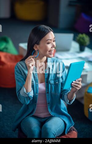 Schöne glückliche Frau, ihren neuen Ohrring berühren Stockfoto