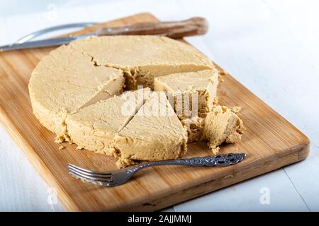 In Scheiben geschnittener Tahini-Halva auf Holzbakkboden. Stockfoto