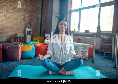 Gerne hübsche Frau üben Meditation zu Hause Stockfoto