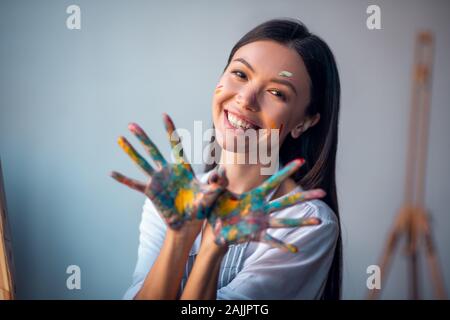 Frohe glückliche Frau ihre Hände auf sie, Stockfoto