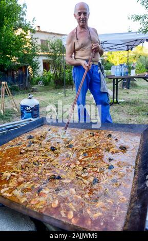 Man Paella Kochen im Freien für 100 Personen Stockfoto