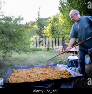 Man Paella Kochen im Freien für 100 Personen Stockfoto