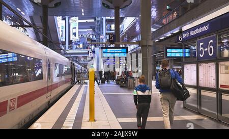 Mann und Junge packen, gehen durch den Berliner Bahnsteig mit einem ICE-Zug, Hochgeschwindigkeits-Intercity-Express, der im Bahnhof ruht. Stockfoto