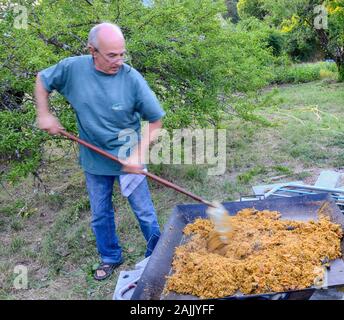 Man Paella Kochen im Freien für 100 Personen Stockfoto