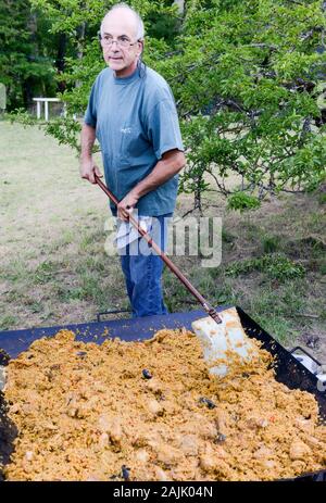 Man Paella Kochen im Freien für 100 Personen Stockfoto