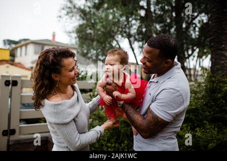 Biracial Paar Holding & lächelnd bei Baby Stockfoto