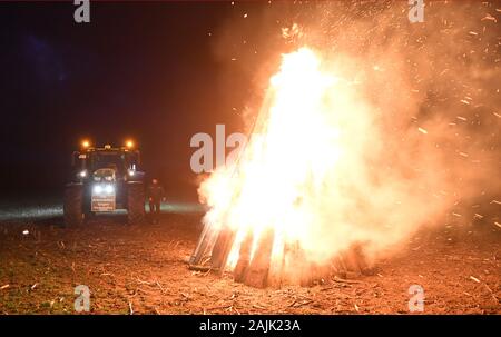 Kemnitz Neundorf, Deutschland. 04 Jan, 2020. Wurde ein Feuer lodert auf einem Feld in der Nähe von Greifswald Kemnitz-Neuendorf. Die Initiative "Land schafft Verbindung' in Mecklenburg-Vorpommern Warnung Brände die Aufmerksamkeit auf die Situation der Landwirte zu Zeichnen verwendet hat. Nach Angaben der Veranstalter, die Situation der regionalen Landwirtschaft ist kritisch. Die aktuelle Agrar- und Umweltpolitik gefährdet Betriebe und die gesellschaftlich gewünschte regionale Lebensmittelproduktion und ist keine Garantie für mehr Grundwasser, Umwelt- und Tierschutz. Quelle: Stefan Sauer/dpa/Alamy leben Nachrichten Stockfoto