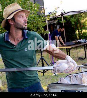 Mann Vorbereitung Spieß braten Huhn draußen Provence Frankreich Stockfoto