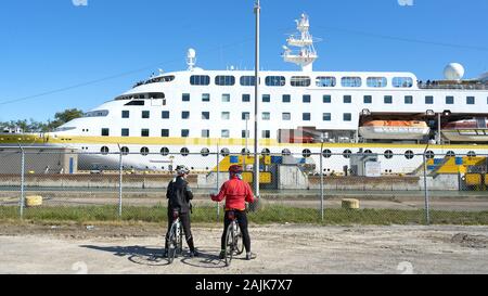 MS Hamburg Luxus kleines Kreuzfahrtschiff im Welland-Kanal, der zwischen Eriesee und Ontario verläuft. Zwei Radfahrer machen eine Pause, um das Schiff zu sehen. Stockfoto