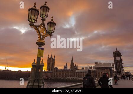 Westminster, London, 4. Jan 2020. Touristen und Einheimische, die das Londoner genießen Sie den schönen Sonnenuntergang auf die Westminster Bridge mit dem Parlament in den Hintergrund. Ruhe und trockenen Bedingungen in London am Ende einer wunderschön sonnigen Tag in der Hauptstadt. Stockfoto