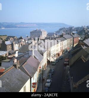 1960er Jahre, historische Luftaufnahme über Youghal, Co Cork, Irland, eine Küstenstadt, die an der Flussmünde des Flusses Blackwater liegt. Eine historische ummauerte Hafenstadt an der Küste von East Cork ist seit Mitte des 19. Jahrhunderts ein Touristenziel. Am Rande eines steilen Flussufers gelegen, hat die Stadt einen langen und schmalen Grundriss. Stockfoto