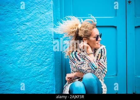 Farbige und trendigen Lifestyle Fashion Portrait von schönen jungen kaukasischen mittleren Alter Frau auf der Suche auf der linken Seite - Blau traditionelle alte Home backgrou Stockfoto
