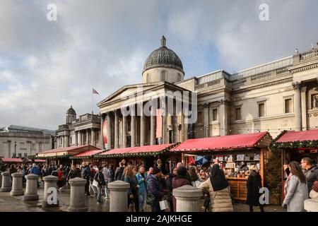 Die National Gallery am Trafalgar Square, mit festlichen Weihnachtsmarkt vor, Außen tagsüber und Leute, London, UK Stockfoto