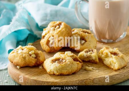 Gebackene Weihnachtsplätzchen. Hausgemachte Kekse Karamell Salz und Kakao trinken auf Holz rustikal Tisch. Stockfoto