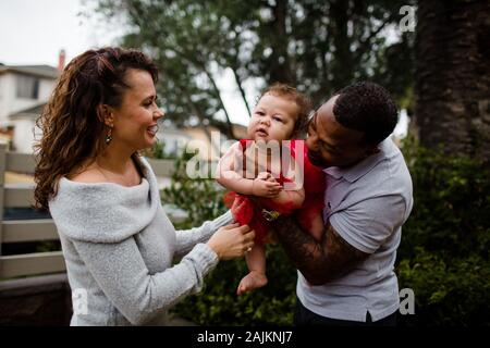 Biracial Paar Holding & lächelnd bei Baby Stockfoto
