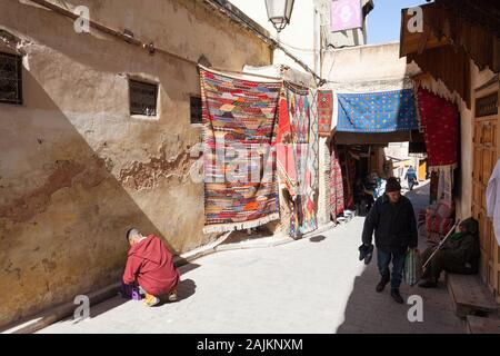 Bunte Teppiche hängen in der Straße von Fes El Bali in Fes (auch bekannt als Fez), Marokko Stockfoto