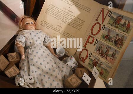 Viktorianische Puppe, Kinderbuch und Holzblöcke in einer Spielzeugschachtel im Bucks County Museum, Aylesbury, Buckinghamshire, Großbritannien Stockfoto