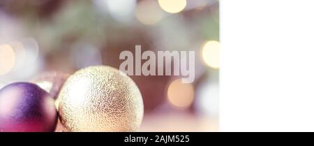 Nahaufnahme von roten und goldenen Christbaumkugel hängen von einem geschmückten Weihnachtsbaum. Retro filter Effekt. Stockfoto