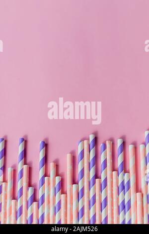Gestreifte trinken Strohhalme in verschiedenen Farben in der Zeile auf gelbem Hintergrund. Minimalismus Konzept. Pop Art Stil. Flach mit Strohhalm für drinki verwendet Stockfoto