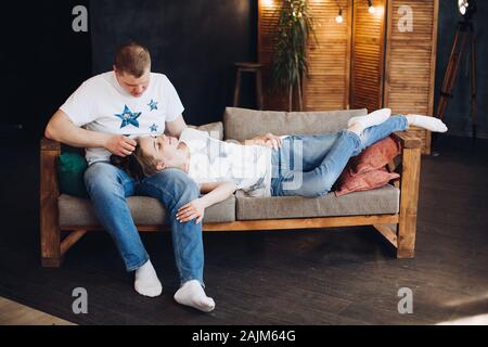 Junges Paar zusammen mit auf dem Bauch im Bett bei Studio. Stockfoto