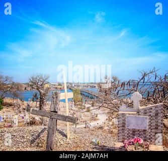 Blick vom Hügel auf der Insel Joal-Fadiout, Senegal. Baobab Bäumen auf dem christlichen Friedhof in Afrika. Es ist die Stadt und lange Holzbrücke. Stockfoto