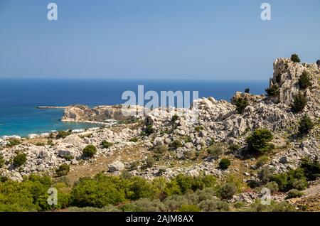 Malerische Aussicht am Stegna Beach auf Geek Insel Rhodos mit Felsen im Vordergrund und das Mittelmeer im Hintergrund an einem sonnigen Tag im Frühjahr Stockfoto