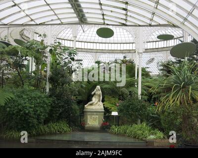 Innerhalb der Kibble Palace Glasshouse in Glasgow Botanic Gardens, einem tropischen Regenwald erwartet mit Statuen und Kunstwerken, einschließlich 'Eve' von tadolini. Stockfoto