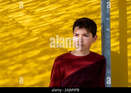 Portrait fröhliche jugendlich lehnte sich gegen gelbe Wand, Weg suchen Stockfoto