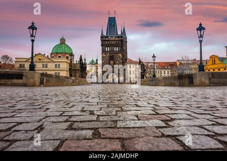 Prag, Tschechische Republik - Die weltberühmte Karlsbrücke (Karluv most) und St. Franz von Assisi Kirche mit einem schönen violetten Himmel und Sonnenuntergang auf einer Wi Stockfoto