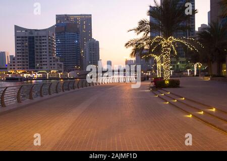 DUBAI, VAE - 27. Dezember 2017: Dubai Marina Promenade bei Sonnenuntergang Zeit Stockfoto