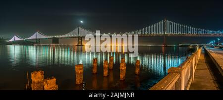 Weitwinkel Panorama der Oakland Bridge bei Nacht von der Innenstadt von San Francisco. Stockfoto