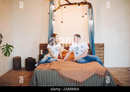 Vorderansicht des Paar sitzen zusammen im Bett bei eingerichteten Studio. Stockfoto