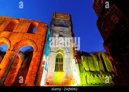 Fountains Abbey Tower bei Nacht, während Weihnachten farbige Beleuchtung Stockfoto