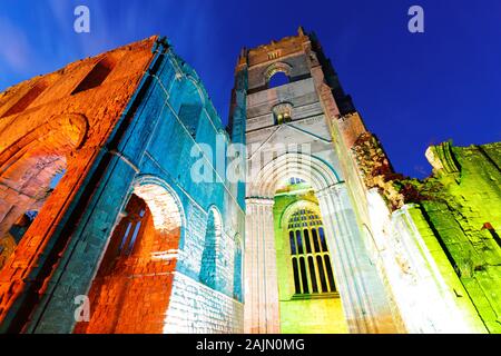 Fountains Abbey Tower bei Nacht, während Weihnachten farbige Beleuchtung Stockfoto