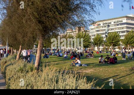 Konak, Izmir/Türkei-09/08/2019: Menschen ruhen am Meer. Die Metropolitan Municipality in Izmir ist im Hintergrund zu sehen. Stockfoto