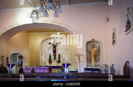 Die einfache Einrichtung der religiösen Kunst und Kirchenbänke in St. Ann's Katholische Kirche in Tubac, AZ Stockfoto