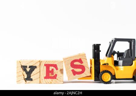 Spielzeug Gabelstapler halten Holz schreiben Block s Wort ja auf weißem Hintergrund zu vervollständigen Stockfoto