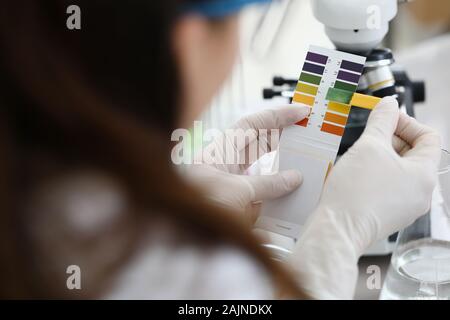 Weibliche Chemiker holding Lackmuspapier in Händen Stockfoto