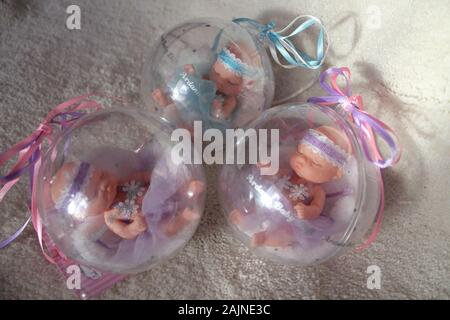 Little Baby Puppe in Crystal Ball mit bunten Bändern für Dekoration auf Winterurlaub oder Geschenk für Mädchen Stockfoto