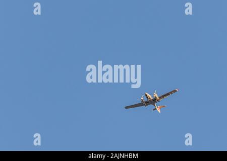 Zweimotorigen Kleinflugzeug fliegt in den blauen wolkenlosen Himmel Stockfoto