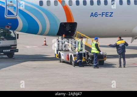 Das Bodenpersonal in der Nähe des Förderband für Gepäck im Flugzeug. Georgien, Tiflis, 2019-04-10 Stockfoto