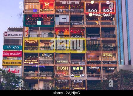 Am Abend Blick auf die Gebäude mit Balkonen, in denen Cafés, Geschäfte und Bars befinden. District 1 Ho Chi Minh, Vietnam: 2019-10-08 Stockfoto