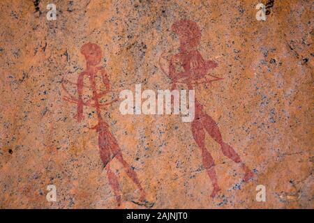 Primitiven alten Bushman Felsmalereien Kunst - zwei Jäger oder Krieger mit Pfeil und Bogen durch die San Stamm in Rot auf Orange Rock Stockfoto