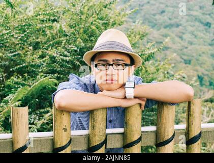 Portrait von asiatischen reisenden Mann mit Natur Hintergrund im Eco Resort im Sommer. Stockfoto