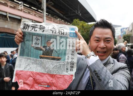 Peking, Japan. 1 Apr, 2019. Ein Mann hält ein Stück Zeitung über Japan's Chief Cabinet Secretary Yoshihide Suga Holding aloft ein gerahmtes Bild von 'Reiwa', der Name des neuen Japan ära, während einer Pressekonferenz in Tokyo, Japan, April 1, 2019. Die japanische Regierung hat am 1. April 2019, dass "Reiwa' wird der Name des neuen Japan Ära werden am 1. Mai 2019, als Kronprinz Naruhito steigt die Chrysantheme Thron die Nachfolge seines Vaters Kaiser Akihito zu starten. Credit: Du Xiaoyi/Xinhua/Alamy leben Nachrichten Stockfoto