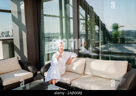 Hübsche junge Frau trinkt ihren Kaffee in einer gemütlichen Weg. Stockfoto